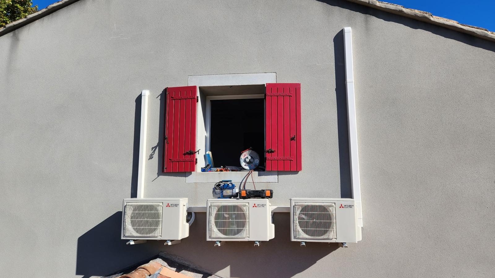 Trois groupes extérieurs de climatisation Mitsubishi Electric posés sur une façade
