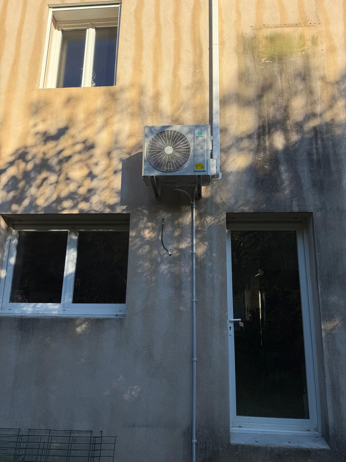 Unité extérieure de climatisation Heiwa fixée en façade, liaisons sous goulotte